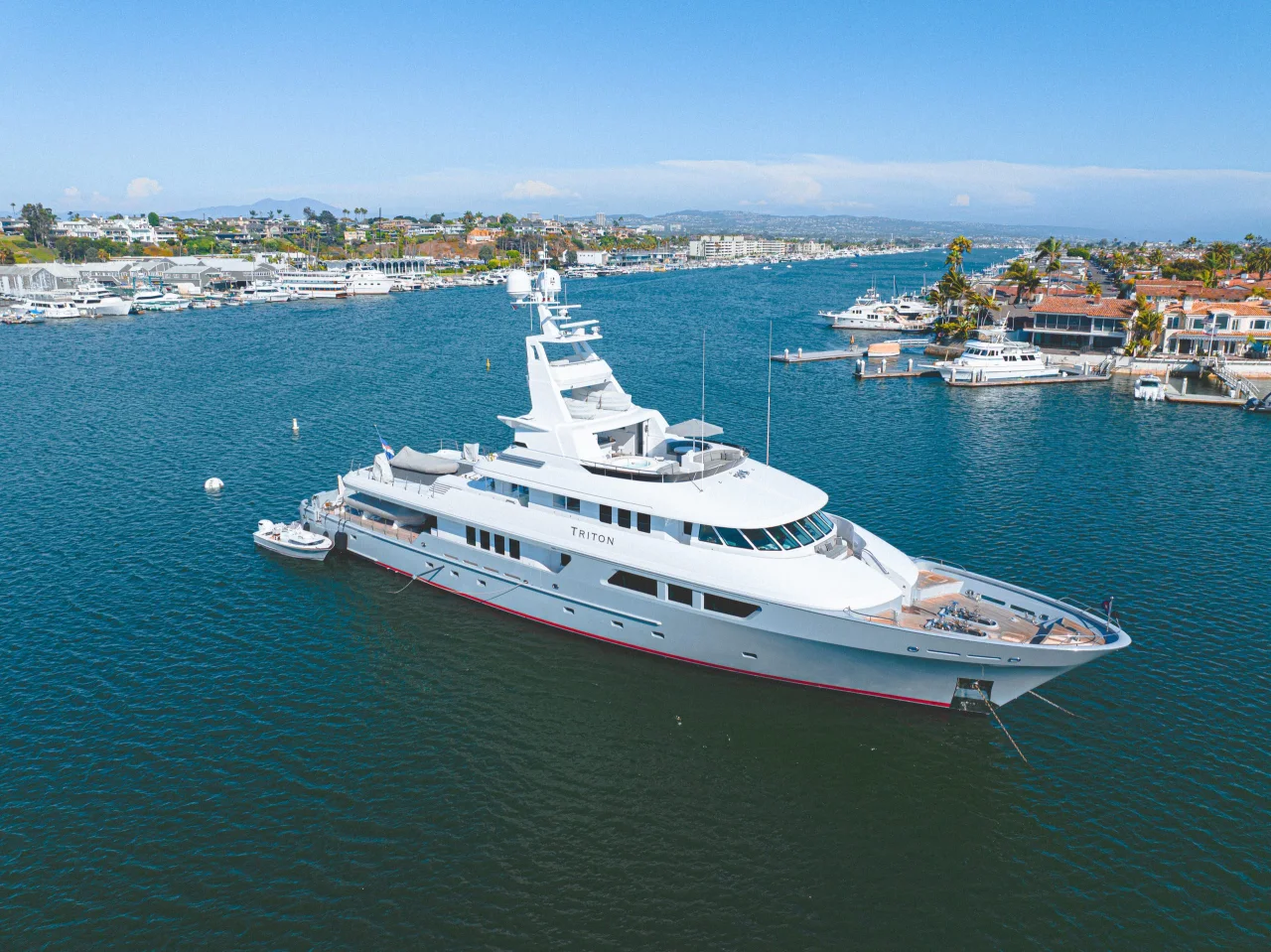 Aerial view of Triton with its open decks and bow above blue harbor water